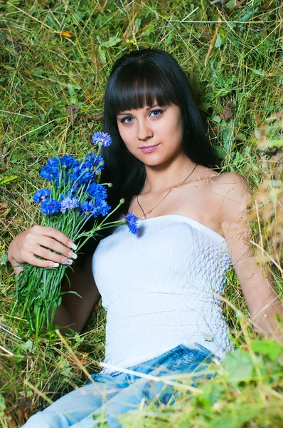 Девушка на сене с цветами — стоковое фото