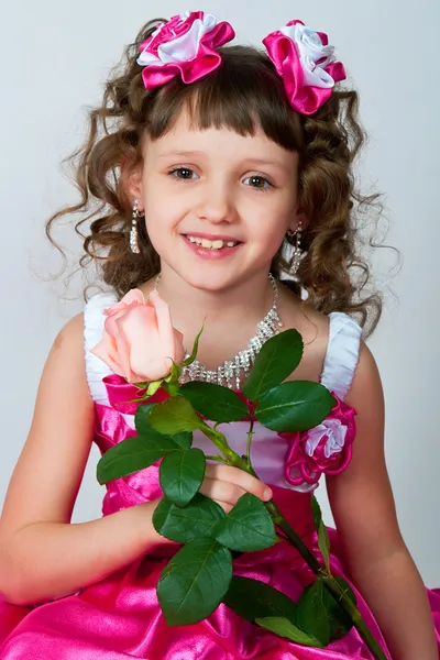 Het meisje in een mooie jurk met roos — Stockfoto