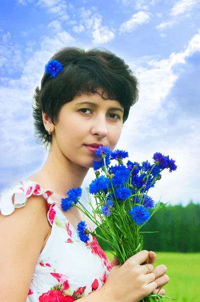 Beautiful girl with a bouquet of cornflowers — Stock Photo, Image