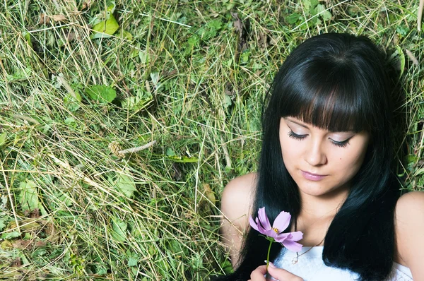 Das Mädchen auf Heu mit Blumen — Stockfoto