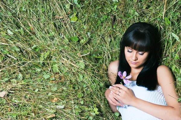 Dívka na seno s květinami — Stock fotografie