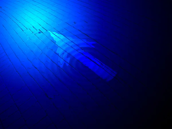 Абстрактное синее освещение, покрашенный белый указатель направления над кирпичом . — стоковое фото