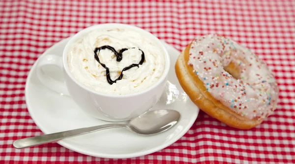Donuts met koffie op tafel. — Stockfoto