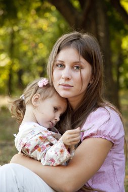 Little girl and mother in the park clipart