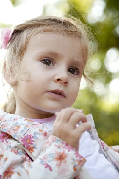 Söt liten flicka i en park — Stockfoto