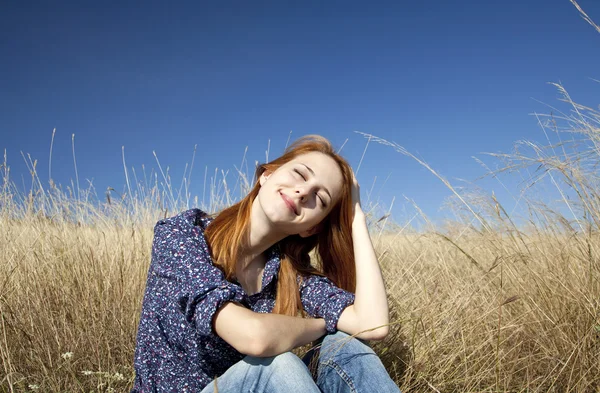 Őszi füvön boldog vörös hajú lány portréja. — Stock Fotó
