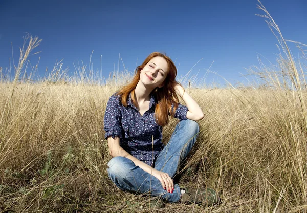 Porträtt av glad rödhårig tjej på hösten gräs. — Stockfoto