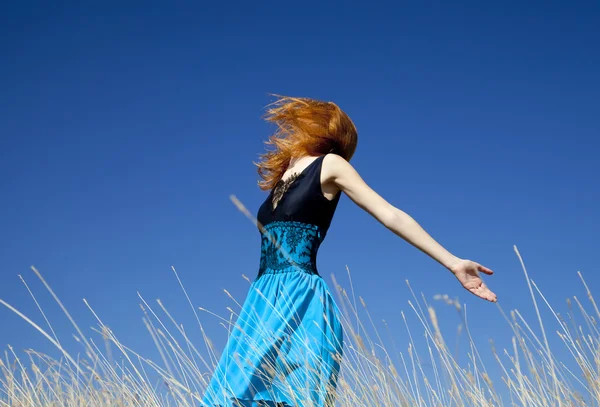 Roodharige meisje op winderige veld. — Stockfoto