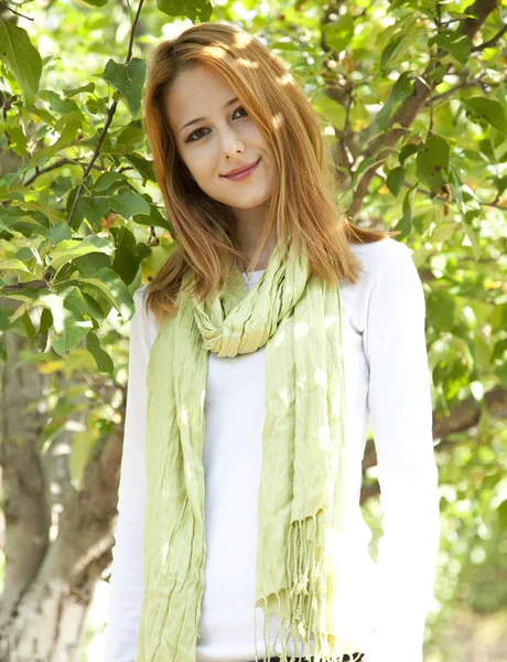 リンゴの木の近くに立って美しい若い赤毛の女性. — ストック写真