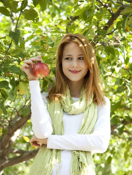 Gyönyörű fiatal vöröshajú nő közelében az almafa. — Stock Fotó