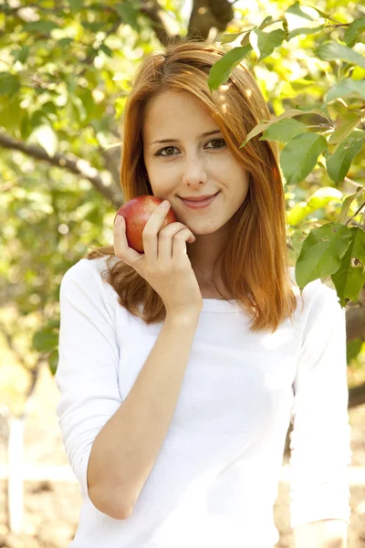 Krásná mladá zrzka žena stojící u jabloně. — Stock fotografie
