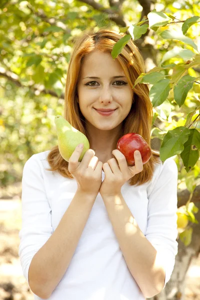 站在苹果树附近美丽年轻的红发女子. — 图库照片