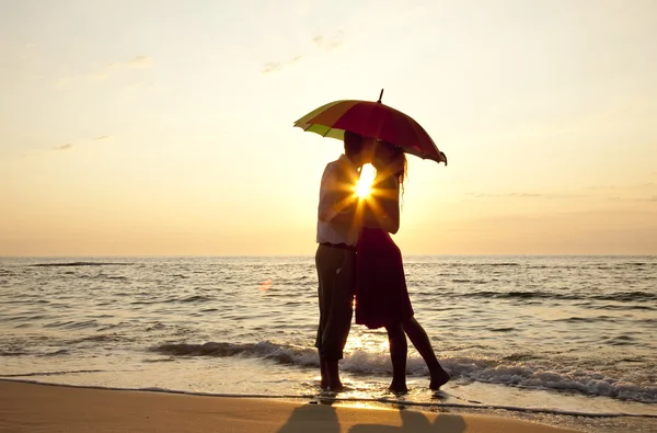 Coppia baci in spiaggia al tramonto . — Foto Stock