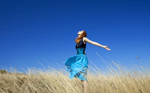 Rothaarige Mädchen auf windigem Feld. — Stockfoto