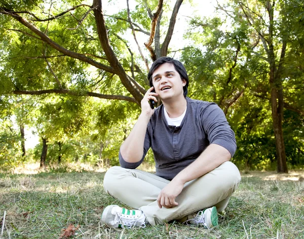 Beautiful brunette men calling by mobile at outdoor. — Stock Photo, Image