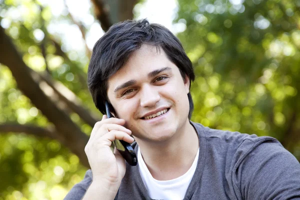Όμορφη μελαχρινή άνδρες κλήση από κινητό σε εξωτερικούς χώρους. — Φωτογραφία Αρχείου