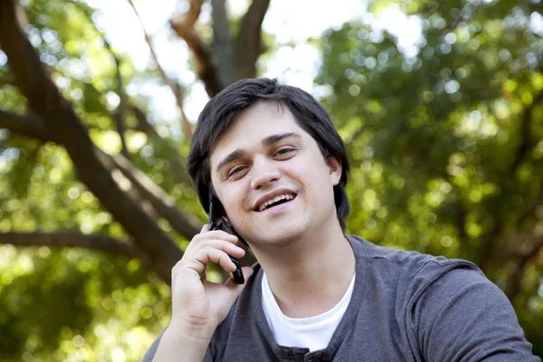 Vacker brunett män ringer genom mobil på utomhus. — Stockfoto