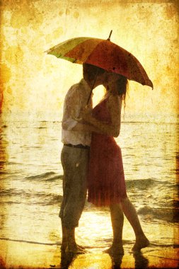 Couple at the beach in sunset. clipart