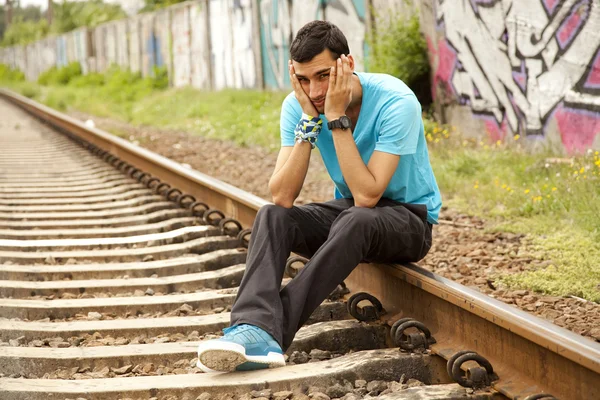 Мальчик сидит на железной дороге — стоковое фото