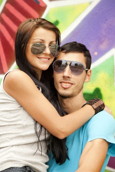 Graffiti arka yanında genç bir çift — Stok fotoğraf