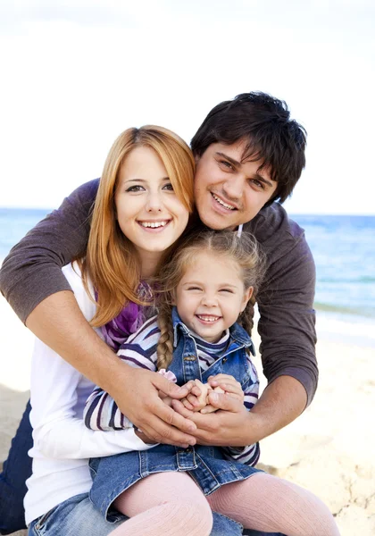 Młoda rodzina na plaży jesienią. — Zdjęcie stockowe