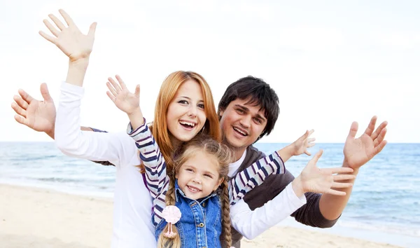 Giovane famiglia in spiaggia in autunno — Foto Stock