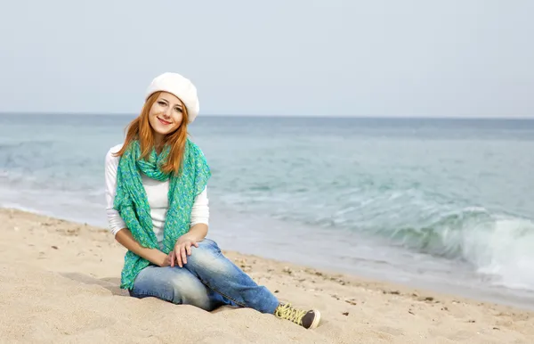 Jovem menina bonita sentada na praia — Fotografia de Stock