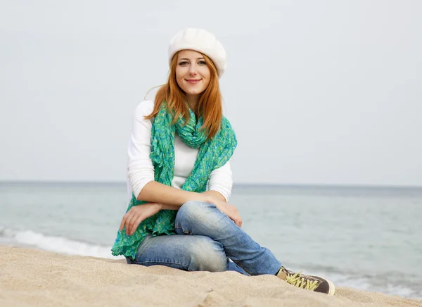 Jovem menina bonita sentada na praia — Fotografia de Stock