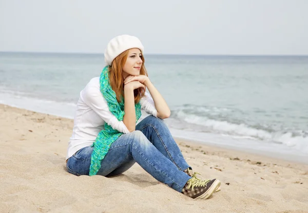 年轻漂亮的女孩坐在沙滩上 — 图库照片