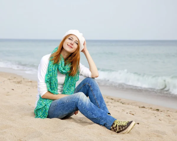 Junges schönes Mädchen sitzt am Strand — Stockfoto