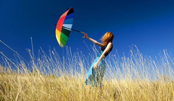 Руда дівчина з парасолькою на вітряній траві . — стокове фото