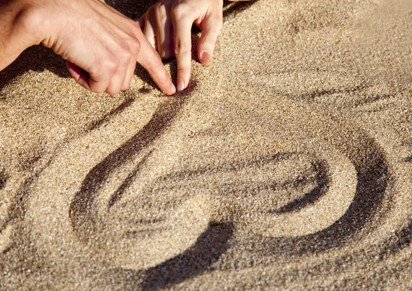 Drawing heart at sand — Stockfoto