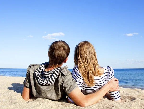 Erkek ve dişi arkasında mavi deniz kıyısında mutlu çifti — Stok fotoğraf