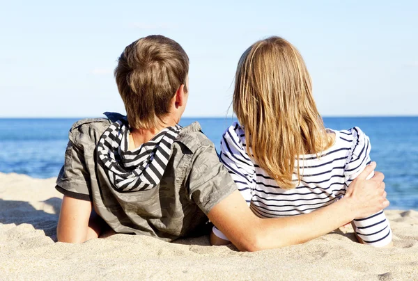 Erkek ve dişi arkasında mavi deniz kıyısında mutlu çifti — Stok fotoğraf