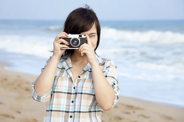 Mädchen mit Kamera am Meer. — Stockfoto