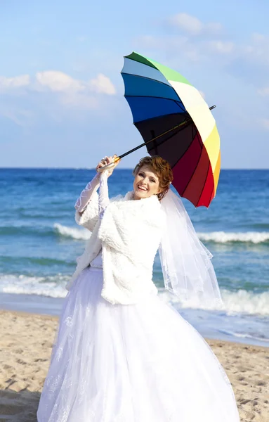 Jonge bruid op het strand met paraplu. — Stockfoto