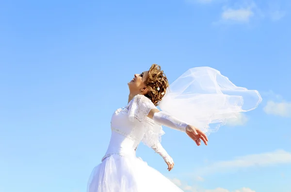 Jonge bruid bij blauwe hemelachtergrond — Stockfoto