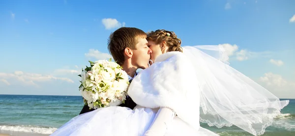 Frisch verheiratete Paare küssen sich am Strand. — Stockfoto