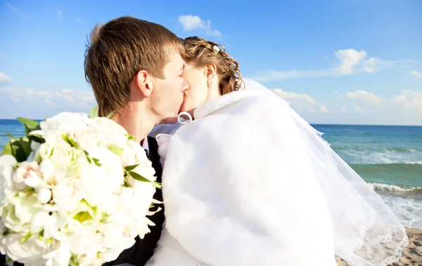 Frisch verheiratete Paare küssen sich am Strand. — Stockfoto