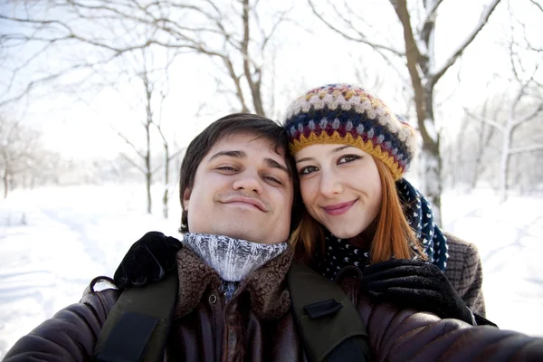 Hermosa pareja hacer una foto de sí mismos en el parque de invierno . — Foto de Stock