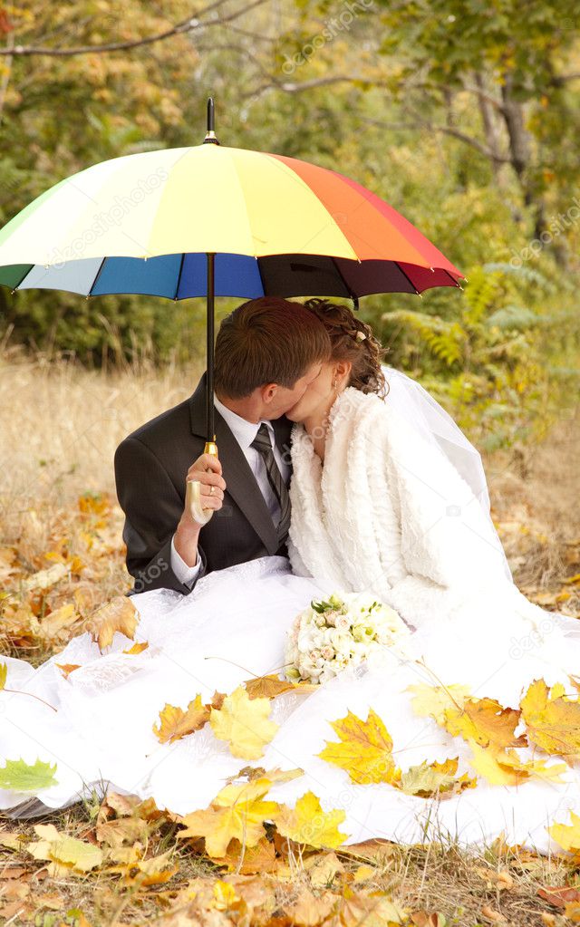 Couple sitting at the park with umbrella