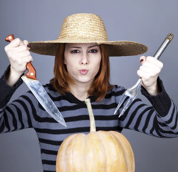 Menina engraçada em boné e garfo com faca tentar comer uma abóbora . — Fotografia de Stock