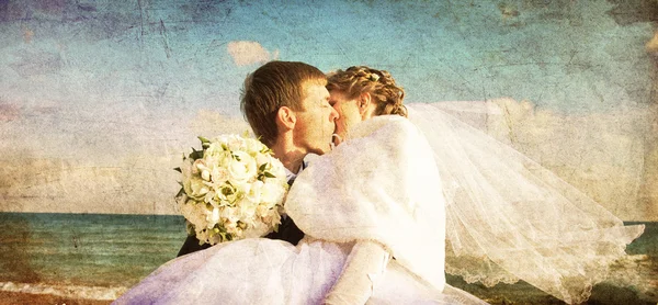 Recién casada pareja besándose en la playa . — Foto de Stock