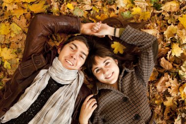 Couple lying in the park in fall