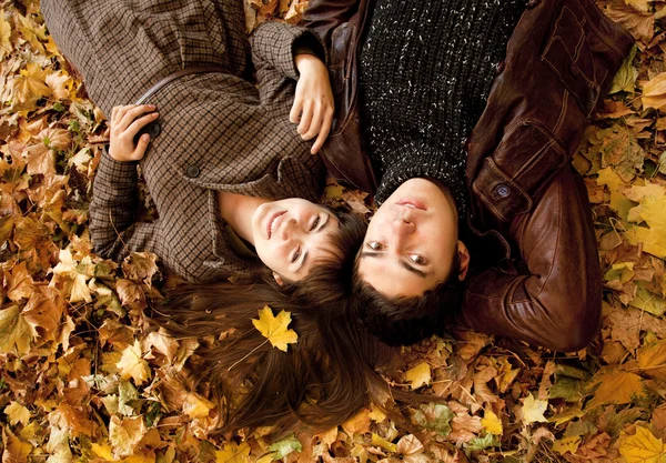 Pár ležící v parku na podzim — Stock fotografie