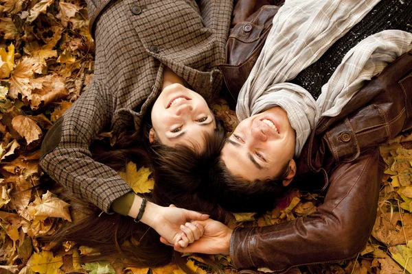 Couple lying in the park in fall — Stock Photo, Image