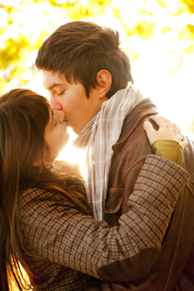 Casal beijando no parque ao pôr do sol — Fotografia de Stock