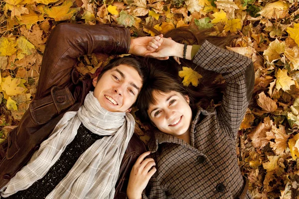 Couple lying in the park in fall — Stockfoto