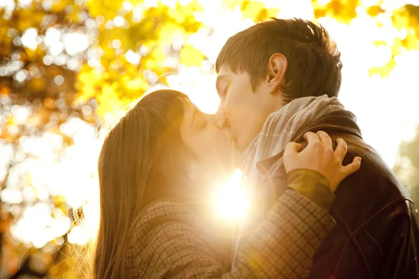 Casal beijando no parque ao pôr do sol — Fotografia de Stock