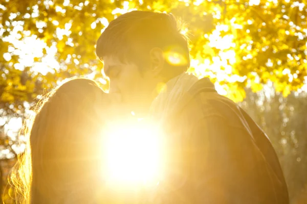 Couple kissing in the park at sunset — Stock Photo, Image